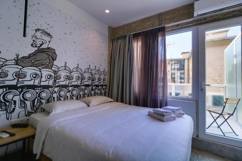 1 dormitorio con 1 cama con un mural en la pared en athensdot en Atenas