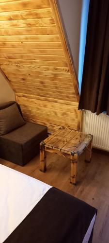 a room with a bed and a table and a couch at Nicole Hotel & Restaurant in Samokov