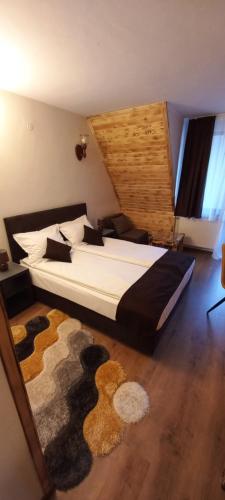 a bedroom with a large bed and a rug at Nicole Hotel & Restaurant in Samokov