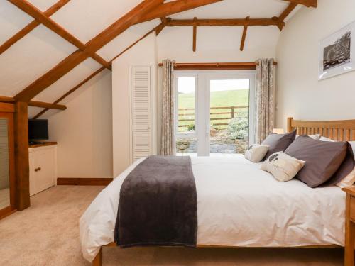 sypialnia z dużym łóżkiem i oknem w obiekcie Little Orchard w mieście Newton Abbot