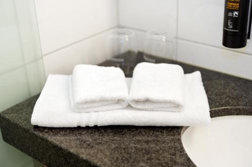 einen Stapel Handtücher auf einer Theke im Bad in der Unterkunft Seehotel Schiff in Mannenbach