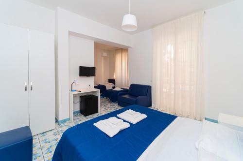 Habitación de hotel con cama azul y sofá en La Casa di Aurora, en Maiori