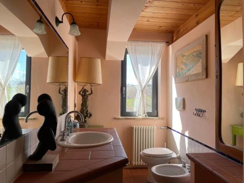 Trecastelliにある"La Casa degli ulivi Art B&B"のバスルーム(洗面台2台、トイレ付)