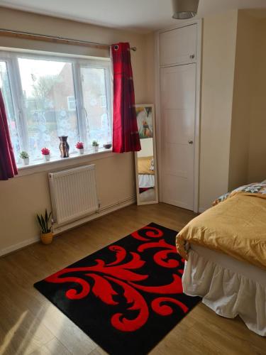 a bedroom with a bed and a red and black rug at Babus International in Cranford
