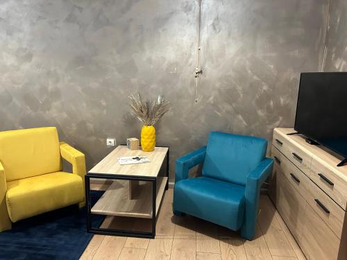 a living room with two chairs and a table and a tv at R34 Boutique Guest House in Veliko Tŭrnovo