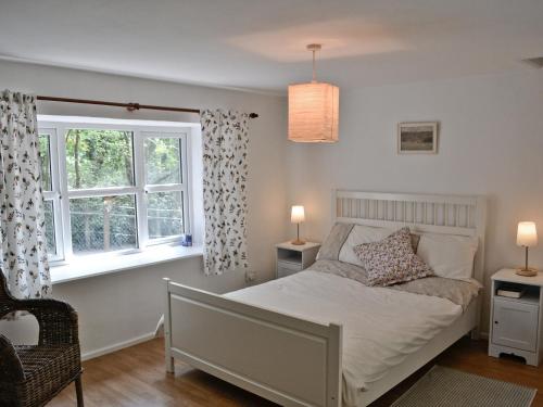 um quarto com uma cama e uma janela em Bridge Cottage em Mitchel Troy