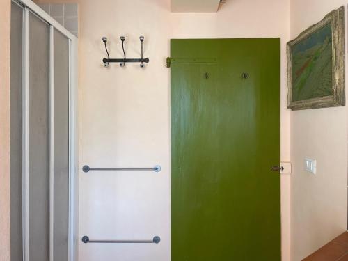 a green door in the corner of a room at "La Casa degli ulivi Art B&B" in Trecastelli