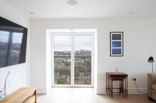 a living room with white walls and a large window at 2 Bed 2 Bath Penthouse With Amazing Views with Free Parking in London