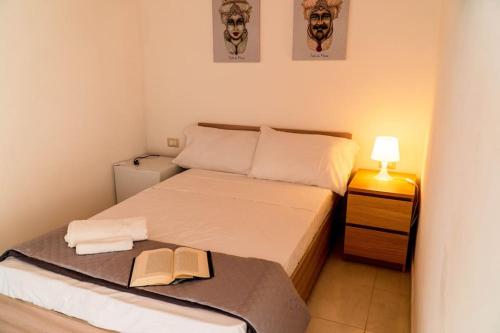 a small bedroom with a bed with a book on it at Casa Charm RosaApartmentsOrtigia in Syracuse