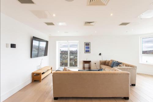 a living room with white walls and a couch at 2 Bed 2 Bath Penthouse With Amazing Views with Free Parking in London