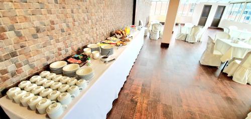 una mesa larga con platos y tazones. en Hotel Boutique Vivenzo, en La Paz