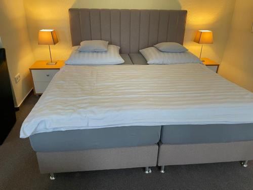 a large bed in a room with two lamps at Ferienwohnung Brunnenhaus in Bad Sassendorf