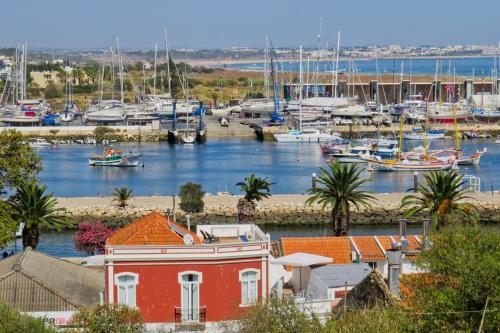 a marina with boats in the water and a red building at New Village Guest House in Lagos