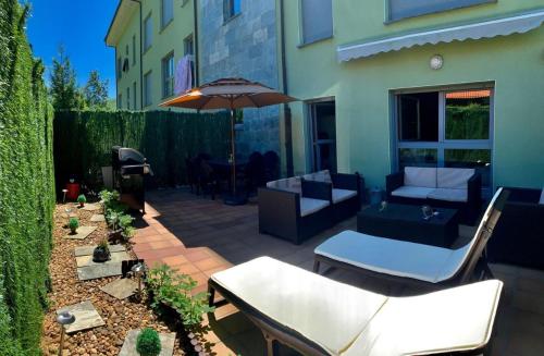 a patio with a couch and an umbrella at APARTAMENTO FELECHOSA in Felechosa