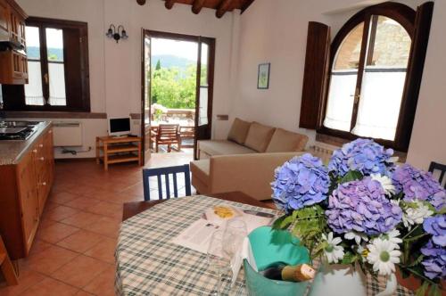 una sala de estar con una mesa con flores azules y blancas en Villa Gradoni, en Monticelli Brusati