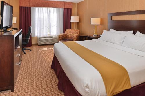 a hotel room with a large bed and a television at Holiday Inn Express Hotel & Suites Gillette by IHG in Gillette