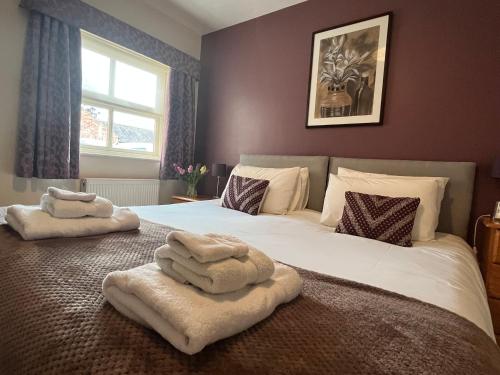 a bedroom with a bed with two towels on it at Wold Escapes, Highfield Farm in Great Driffield