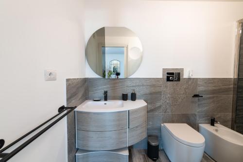 a bathroom with a sink and a toilet and a mirror at Casa Andrew New in Rome