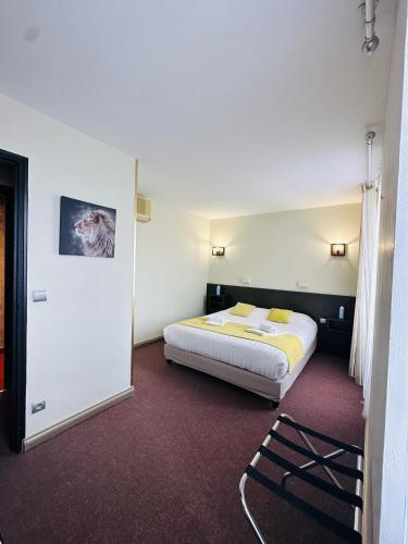 a hotel room with a bed in a room at Logis Hôtels - Hôtel et Restaurant Le Lion d'Or in Gramat