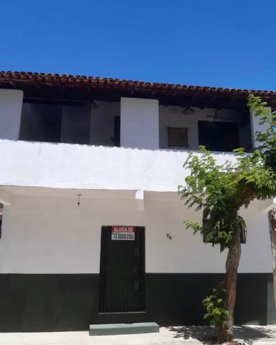 a white building with a sign in front of it at Casa Pau Brasil in Prado