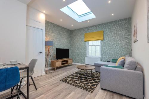 a living room with a couch and a tv at The Cotswold Woodland by Fortuna Property Portfolio in Cheltenham