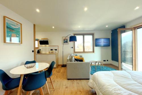une chambre avec un lit, une table et des chaises dans l'établissement L'Albigny - Lovely Studio - 150 m beach, à Annecy