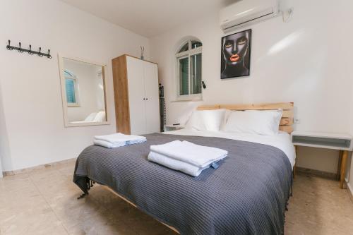 una camera da letto con un letto e due asciugamani di ARISTO Machne Yehuda boutique apartments a Gerusalemme