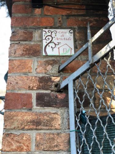 a sign on the side of a brick wall at Casa di Aristide in Erba