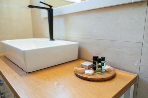 a bathroom counter with a sink and bottles of alcohol at ARISTO Machne Yehuda boutique apartments in Jerusalem