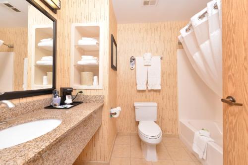 a bathroom with a toilet and a sink and a tub at Holiday Inn Express Hotel & Suites Gillette, an IHG Hotel in Gillette