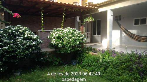 a house with two trees and flowers in the yard at Lar Jampa Beach in Cabedelo