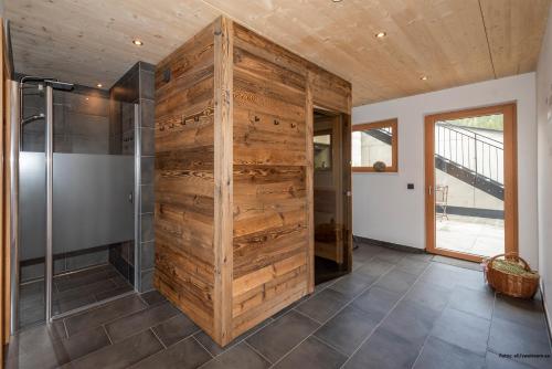 a wooden wall in a bathroom with a shower at TUX MOUNTAIN Apart in Tux