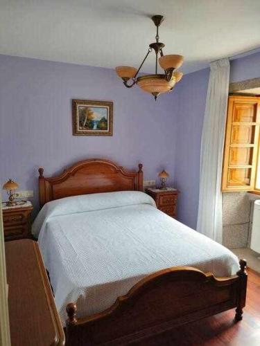 um quarto com uma cama e uma parede azul em Casa Brisas del Mar em Cabana de Bergantiños