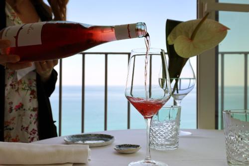 a woman pouring a bottle of wine into a wine glass at dimore di portadibasso in Peschici