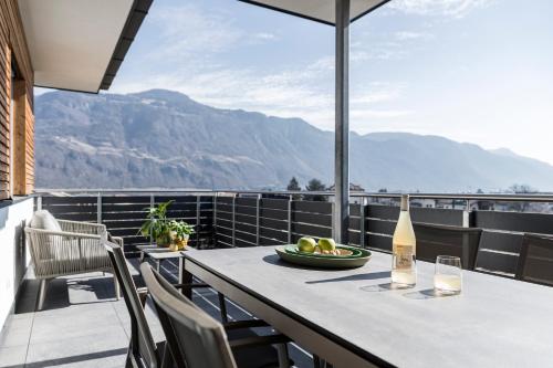 a table on a balcony with a bottle of wine at Haus Wiesenstein in Lana