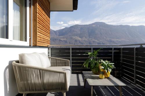 a balcony with two chairs and a table and mountains at Haus Wiesenstein in Lana