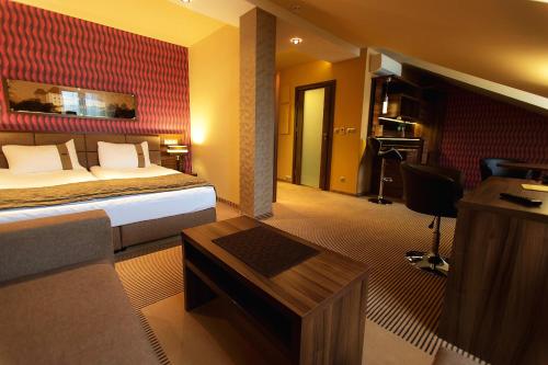 ein Hotelzimmer mit einem Bett und einem Schreibtisch in der Unterkunft Willa Pod Bramą in Sandomierz