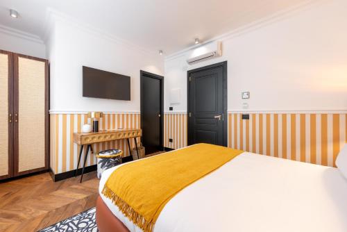 a bedroom with a bed and a tv on the wall at DH Rooms Spiga in Milan