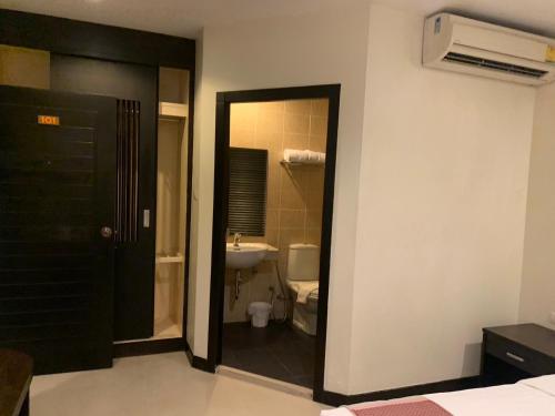 La salle de bains est pourvue d'un lavabo, de toilettes et d'une porte. dans l'établissement Lub Sbuy Hostel, à Phuket