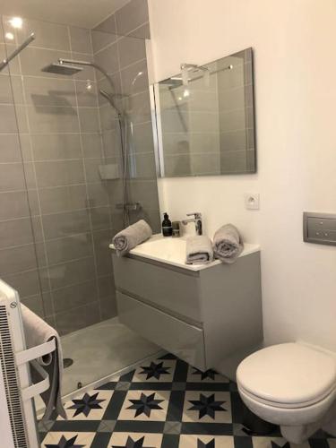 a bathroom with a toilet and a sink and a shower at Appartement Élégant à 2 Pas de la Mer in Perros-Guirec