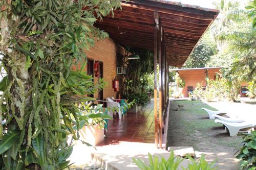 an outdoor patio with white benches and a building at Pousada Penedo in Penedo