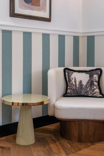 a living room with a chair and a table at DH Rooms Spiga in Milan