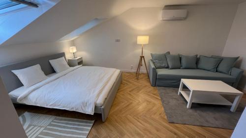 1 dormitorio con 1 cama y 1 sofá en Franco Apartments, en Kežmarok