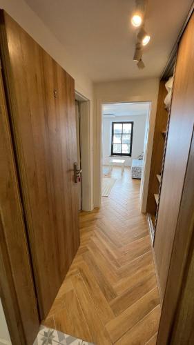 a hallway with a wooden floor and a door at Franco Apartments in Kežmarok