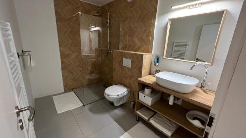 a bathroom with a sink and a toilet and a mirror at Franco Apartments in Kežmarok