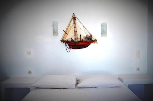 a small boat hanging on a wall above a bed at Summer Residence in Provatas