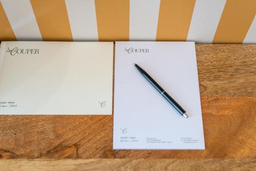 a pencil sitting on top of two pieces of paper at DH Rooms Spiga in Milan