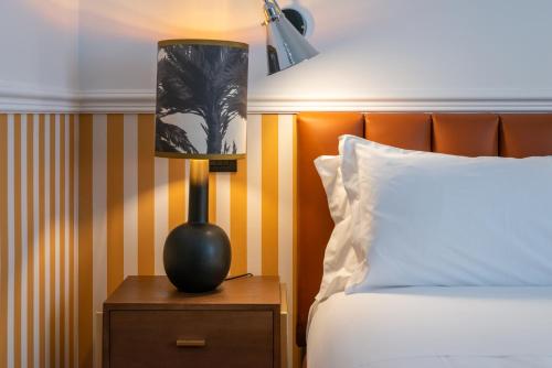 a lamp on a night stand next to a bed at The Couper Spiga in Milan