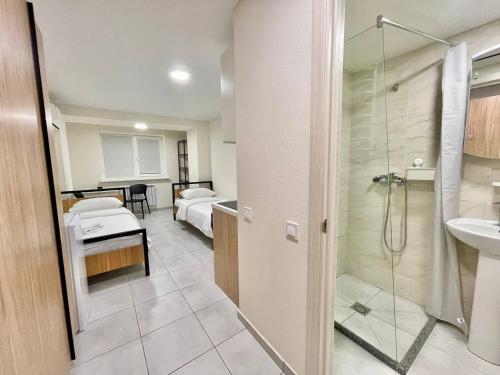 La salle de bains est pourvue d'une douche, d'un lit et d'un lavabo. dans l'établissement GD Apartment osokorky, à Kiev