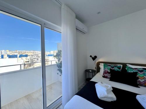 a bedroom with a bed and a large window at Faro Deluxe by Homing in Faro
